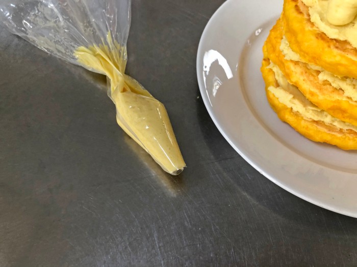 残りのクリームを絞り袋（なければ厚手のビニール袋）に入れ、周りを縁取るように小さく絞り出す。あればキャンドルを飾る。