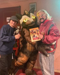 映画「怪獣天国」に出演している怪獣キャラクター（中央）とポーズを取る「怪獣プロレス」の矢口壹琅代表（右）