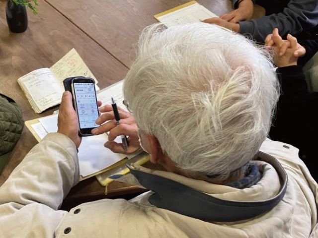 スマホを見ながら情報収集するOさん