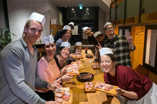 静岡県下田市の海外デジタルノマド交流プログラム「TADAIMA SHIMODA」で寿司を握る体験をしたデジタルノマドたち＝2024年11月7日、静岡県下田市、塚田氏提供