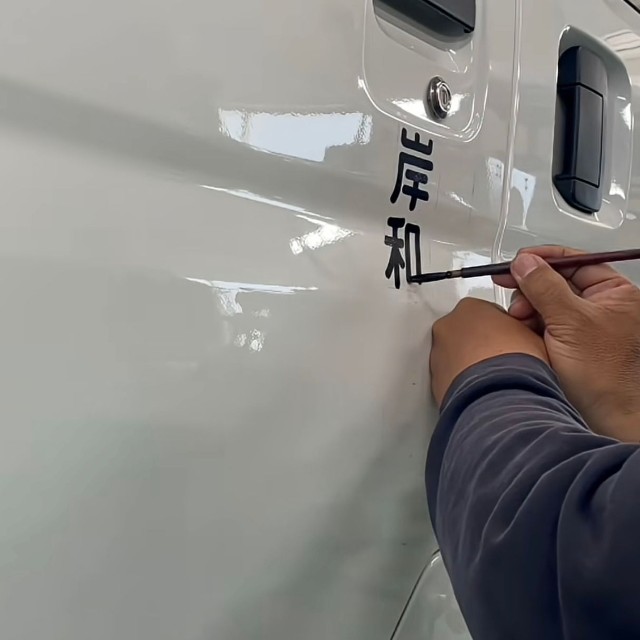 筆で一文字ずつ車体に書き込んでいきます／shu kanbaさん（@signsshu）提供