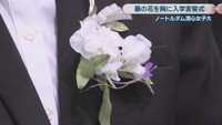 胸に付けた藤の花のコサージュ