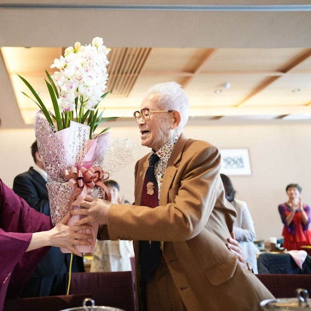 百寿を祝う会には約40人が参加。花束の贈呈が行われた