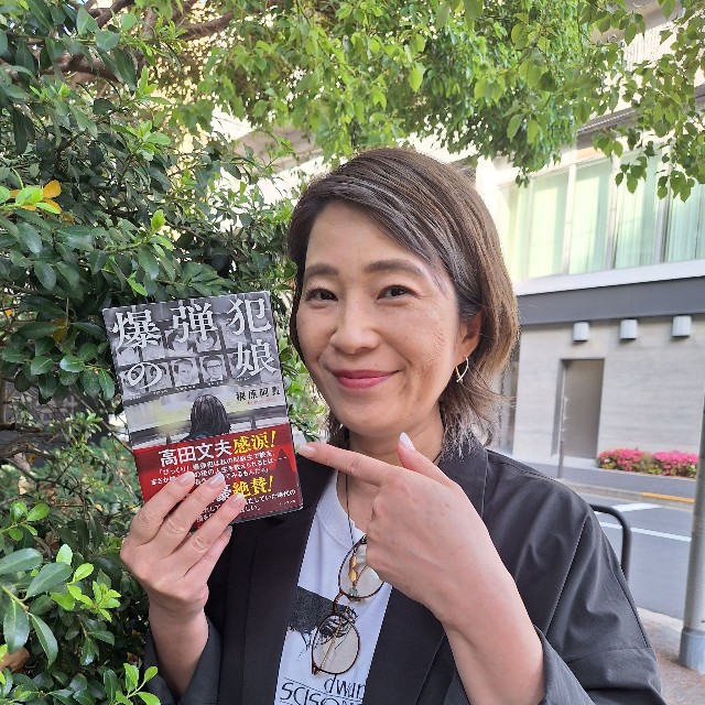 自身の半生をつづった初の著書「爆弾犯の娘」を手にする脚本家の梶原阿貴＝都内
