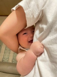 起きているのが祖父母にバレ、腕の間から満面の笑みを見せる／satsukiさん（@nn__sats）提供