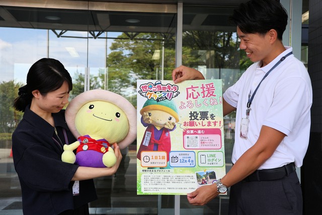 「世界ご当地キャラグランプリ」の投票をお願いするポスターと明智かめまるのぬいぐるみ（亀岡市役所）