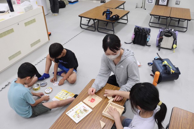 花園大のキャンパス内に開設された学童クラブで、学生と一緒に過ごす子どもら（京都市中京区）
