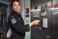 フリゲート艦内のシャワー室を案内するアマイア・フライシャーさん。バストイレも男女共用。シャワー室のドアには、どのシャワーブースが使用中かわかるよう、手製のサインボードが貼られていた=2025年2月11日、ノルウェー・ベルゲンの海軍基地、荒ちひろ撮影