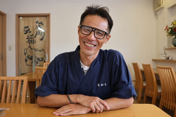 「千かく」の西谷利一さん。木目調で明るい雰囲気の店内でも食事できる