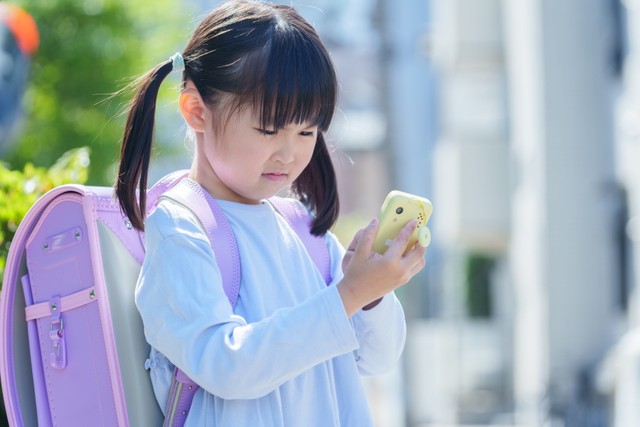連絡用のキッズケータイを使う子ども ※画像はイメージです（polkadot/stock.adobe.com）