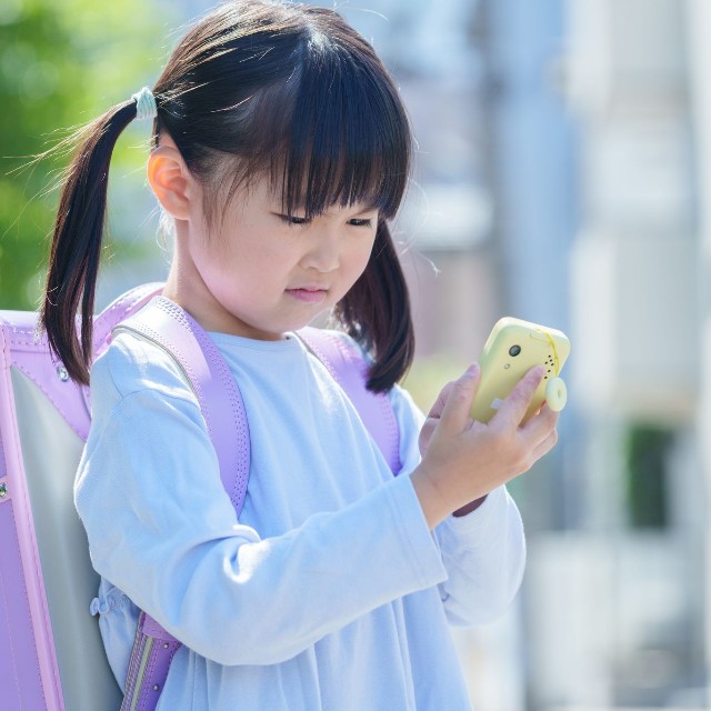 連絡用のキッズケータイを使う子ども ※画像はイメージです（polkadot/stock.adobe.com）