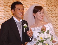 結婚会見で指輪を披露し満面に笑顔を浮かべる鈴木一美さんと鶴見辰吾＝2004年