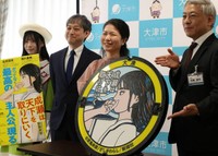 寄贈式で、主人公成瀬あかりを描いたマンホールのふたを囲む作者の宮島さん（右から２人目）ら＝大津市役所