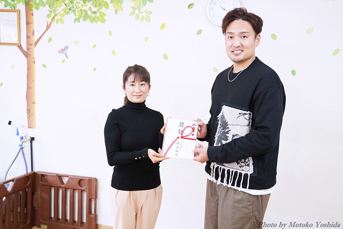 目録を受け取る筆者（アニドネ代表　西平衣里）と秋山投手