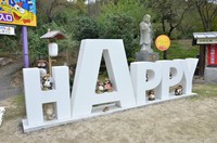 地蔵の手前には「ＨＡＰＰＹ」の英文字の建造物が。周りに人がたくさん集まり、地蔵にハッピーだと感じてもらえるよう、新たに設置したという