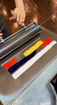 ４色のインキがローラーで混ぜ合わされて…レインボーカラーに！！（画像提供：印刷博物館 ※動画よりキャプチャ）