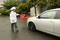 交通取り締まり実習で違反した車を止める記者
