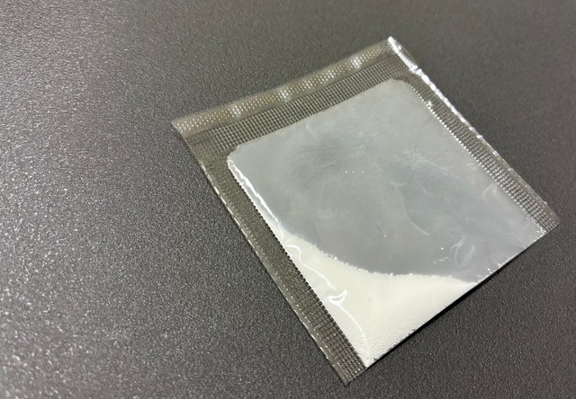 ①袋の下を持ち、角に薬をためる。