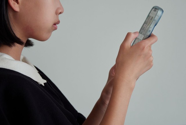 スマートフォンを手にする少女　※この画像はイメージです（zheng giang/stock.adobe.com）