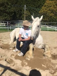 厩舎の砂場で愛馬と戯れる貞松さん