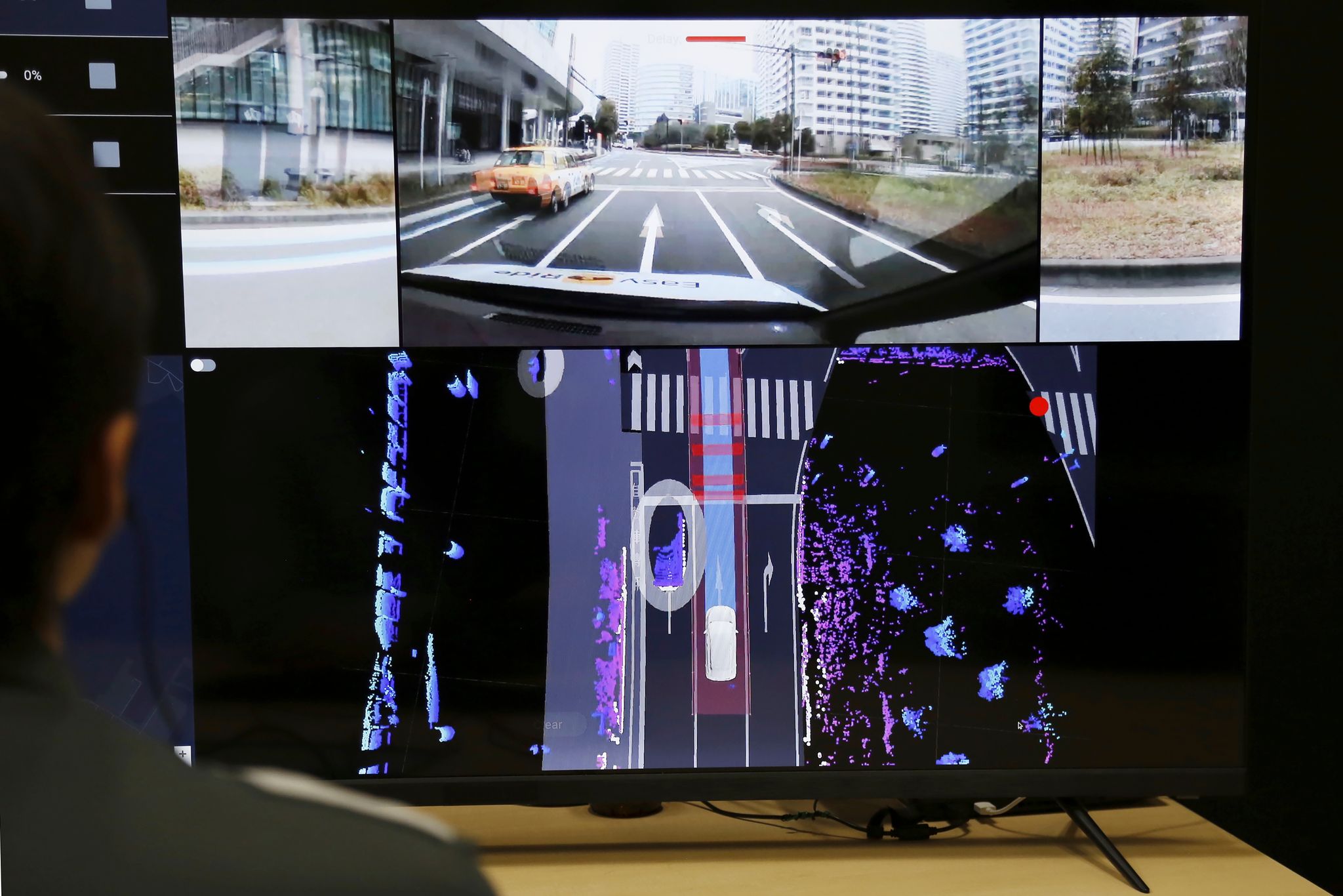 Nissan officials remotely monitor on screens the path and surroundings of the self-driving vehicle being tested on regular roads, so they can step in if problems happen, at Nissan headquarters in Yokohama, near Tokyo, on March 6, 2025.