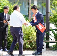 二瓶文隆都議会議員（左）と握手を交わす須藤元気氏