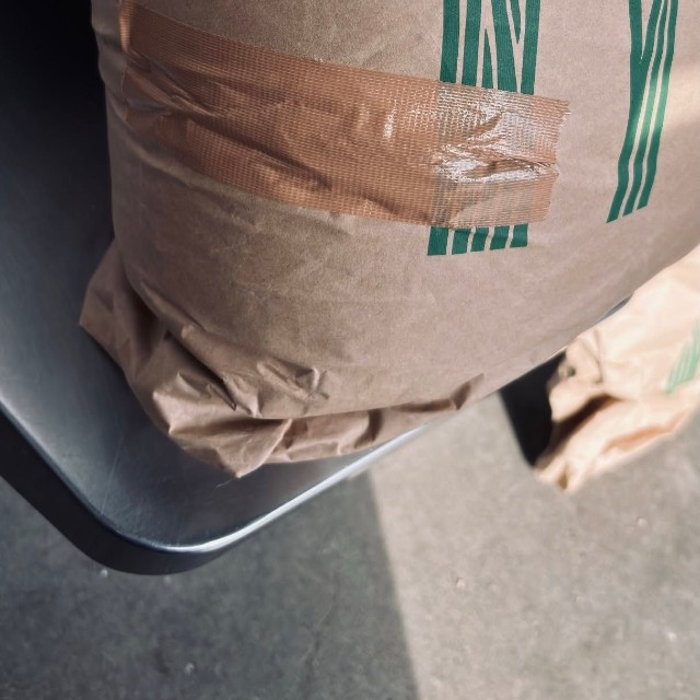 シートベルトの受け口が刺さって破れ、テープで補修された米袋／むちことこつぶさん（@muchi.photo）提供