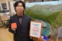 布原駅の駅スタンプを持つ坪内さん