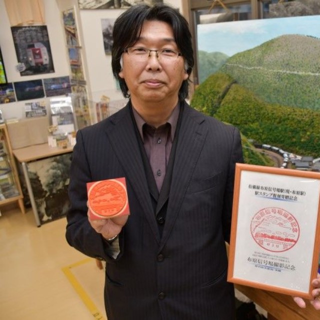 布原駅の駅スタンプを持つ坪内さん