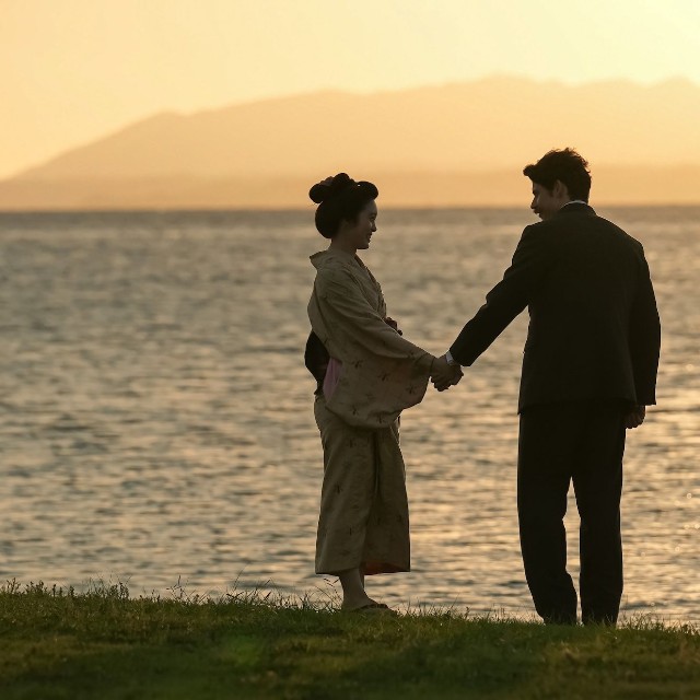 2025年のラストシーン。宍道湖のほとりを手をつないで歩くトキとヘブン　(C)NHK