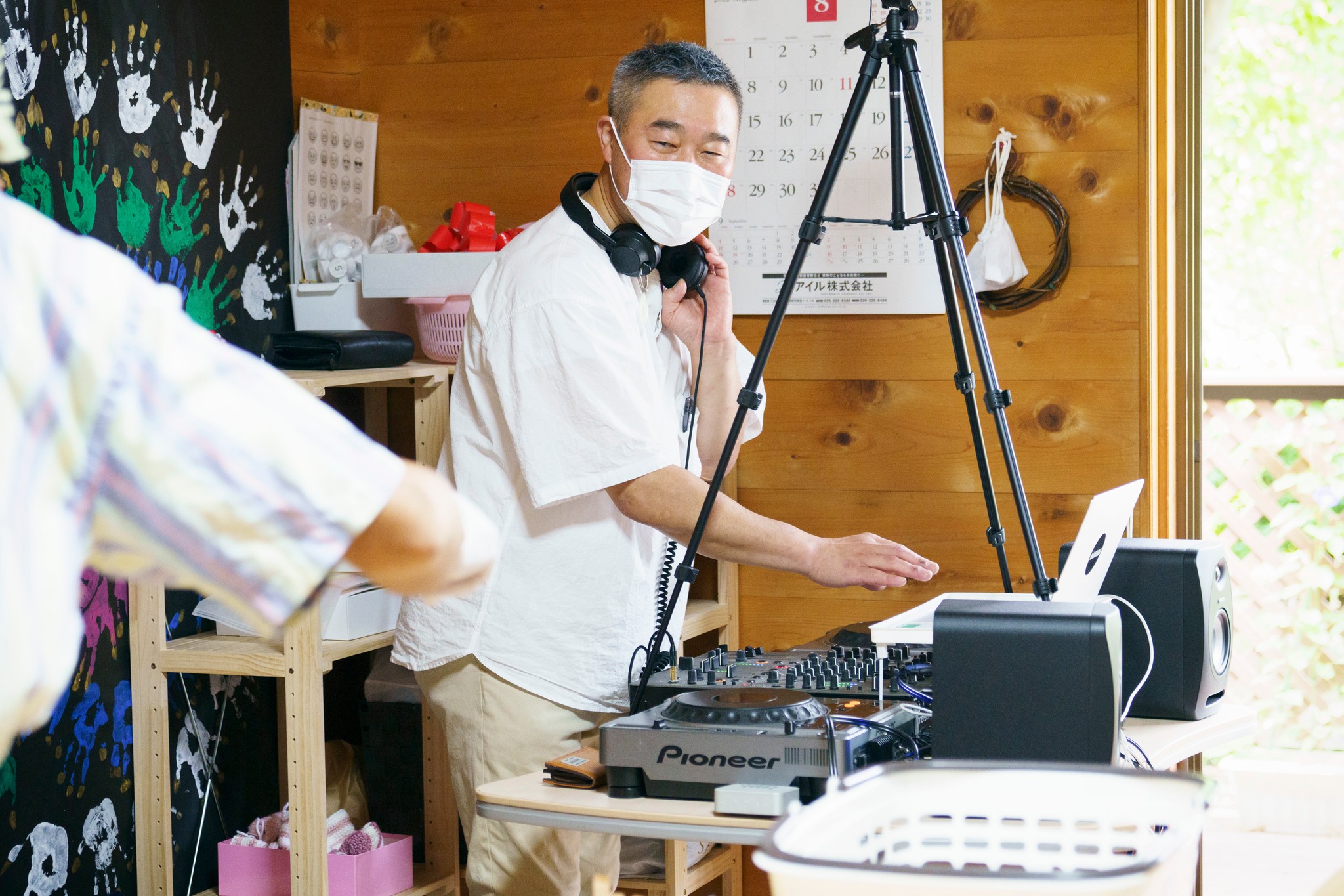 今年からデイサービスを開放して始めた「こども食堂」で、DJ機材を操作してBGMを流す松木さん＝2022年８月20日、長野県千曲市