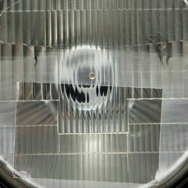 ヘッドライトの下半分を2000番耐水ペーパーで磨いて、長方形のフィルムを貼った状態。