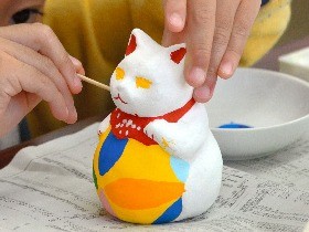 もうすぐ新年　福を招く猫にな～れ　白い素焼き猫に絵付け