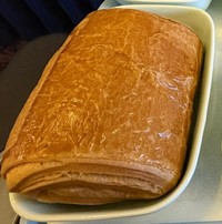 関西空港を出発してすぐに出された、山東航空ビジネスクラスの軽食。パンのサイズが…／どこにでも行くドスコイ（@nihongode_dozo）さん提供※画像はトリミングしています