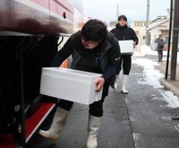 高速バスに間人ガニの入った箱を積み込む水産業者（宮津市鶴賀・宮津駅前）