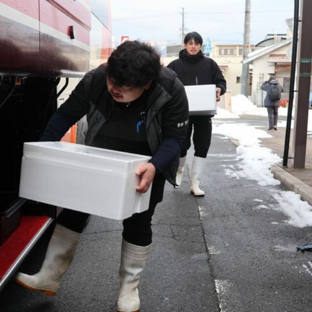 高速バスに間人ガニの入った箱を積み込む水産業者（宮津市鶴賀・宮津駅前）