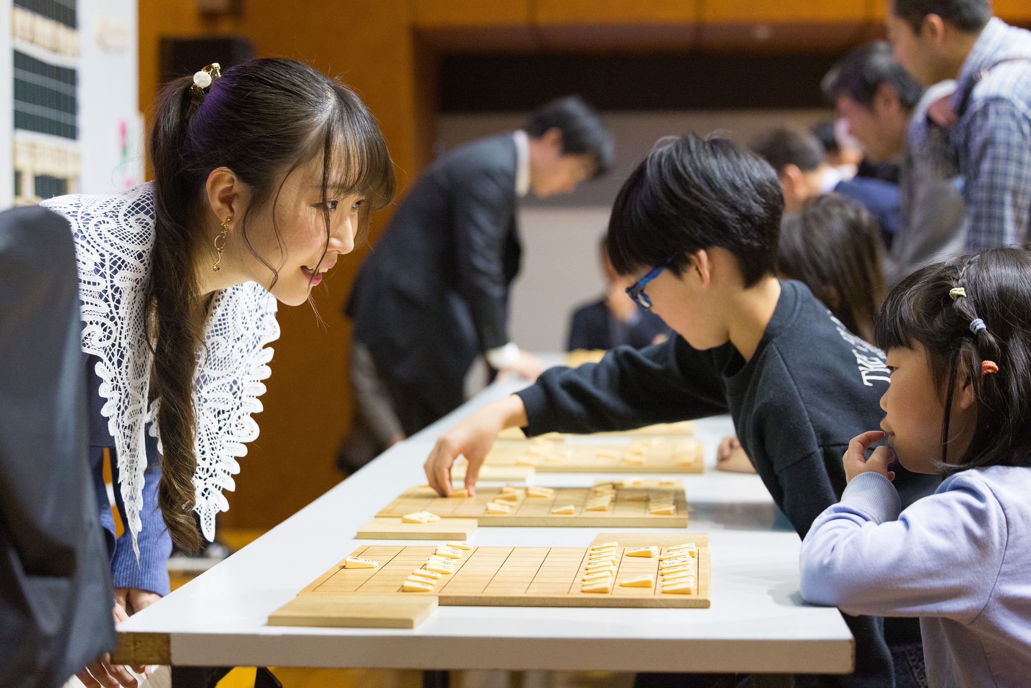 将棋盤をはさんで歓談するプロ棋士とイベント参加者