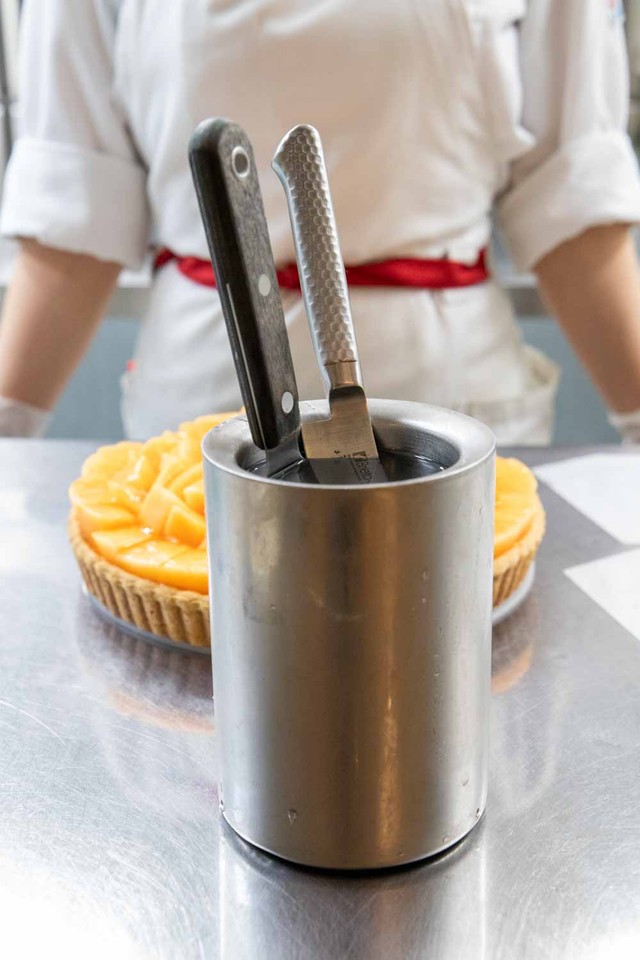 キルフェボンでは、50℃のお湯を入れたステンレス製容器にナイフとケーキサーバーを入れて温めている