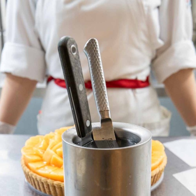 キルフェボンでは、50℃のお湯を入れたステンレス製容器にナイフとケーキサーバーを入れて温めている