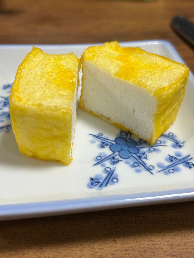 中を割っても、うーん…揚げ豆腐。食べてみると「ふわしゅわ甘々メレンゲの極薄クレープ包みだ！」。