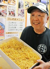 自ら仕上げたゴム焼きそば用の麺を手にする植村さん。色は少し薄くなったが食感は良くなったという（福知山市駅前町・粉もの屋）