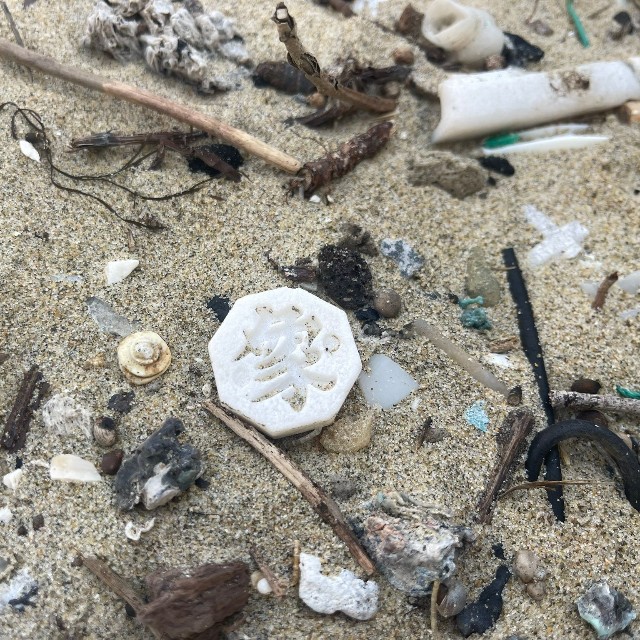 砂浜に落ちていたチャンギの駒。八角形で文字が刻まれている／Dennyさん（@De2_trash_rush）提供