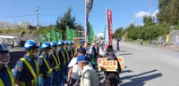 名護市辺野古への新基地建設に抗議してプラカードを掲げる人たちと警備員（提供画像）