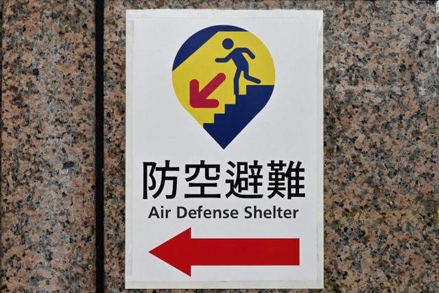台北駅の出入り口に貼られた、防空壕を示す新たなデザインの標識。駅の地下街が壕を兼ねている＝台北市、石田耕一郎撮影