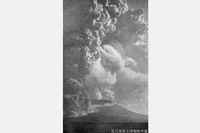 1914（大正3）年1月の「桜島大正噴火」。噴煙がおよそ1万8000メートルまで上がり、大量の軽石や火山灰が降り積もった＝1914年1月12日午前11時30分、鹿児島湾の向こうに桜島を望む、鹿児島県立博物館提供