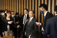 報道陣の取材に応える谷公一国家公安委員長（中央）＝２６日、東京都千代田区