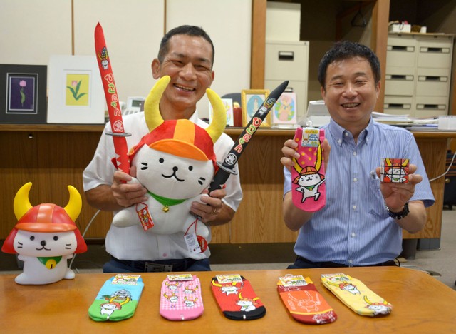 自社が取り扱う靴下を手にする山口社長（右）とぬいぐるみを手にする社員＝京都市中京区・山口青旭堂
