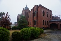 旧奈良監獄の事務棟。低く重い雨空を背景にレンガ造りの建物がくっきりと浮かび上がる