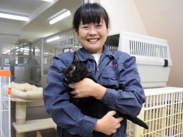保護猫を抱くアミティエのスタッフ山田美奈さん