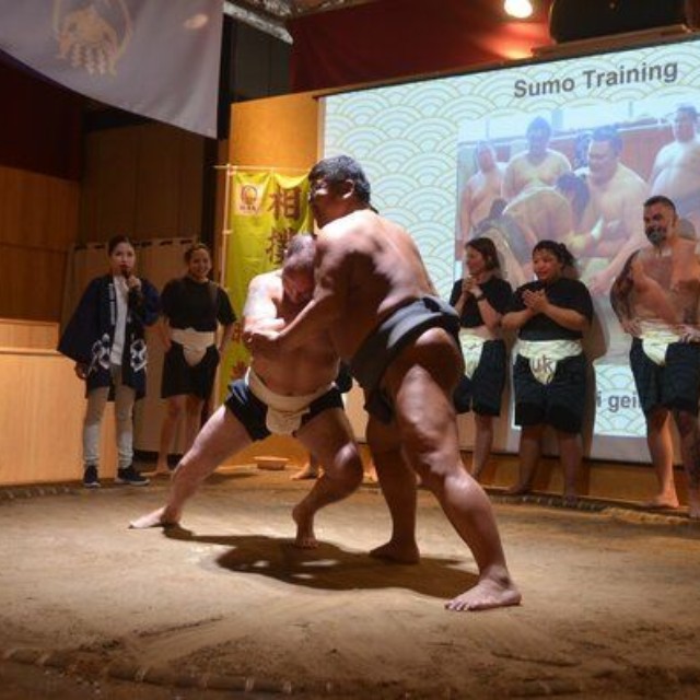 大柄の男性が押してもびくともしない力士（右）